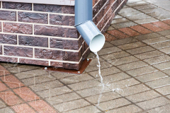 brick wall with a drainpipe in rain